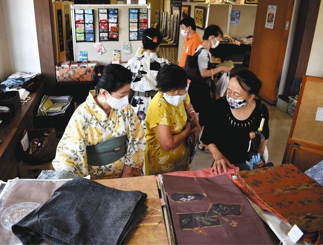 着物などを品定めする来場者ら＝近江八幡市為心町元の白雲館で 