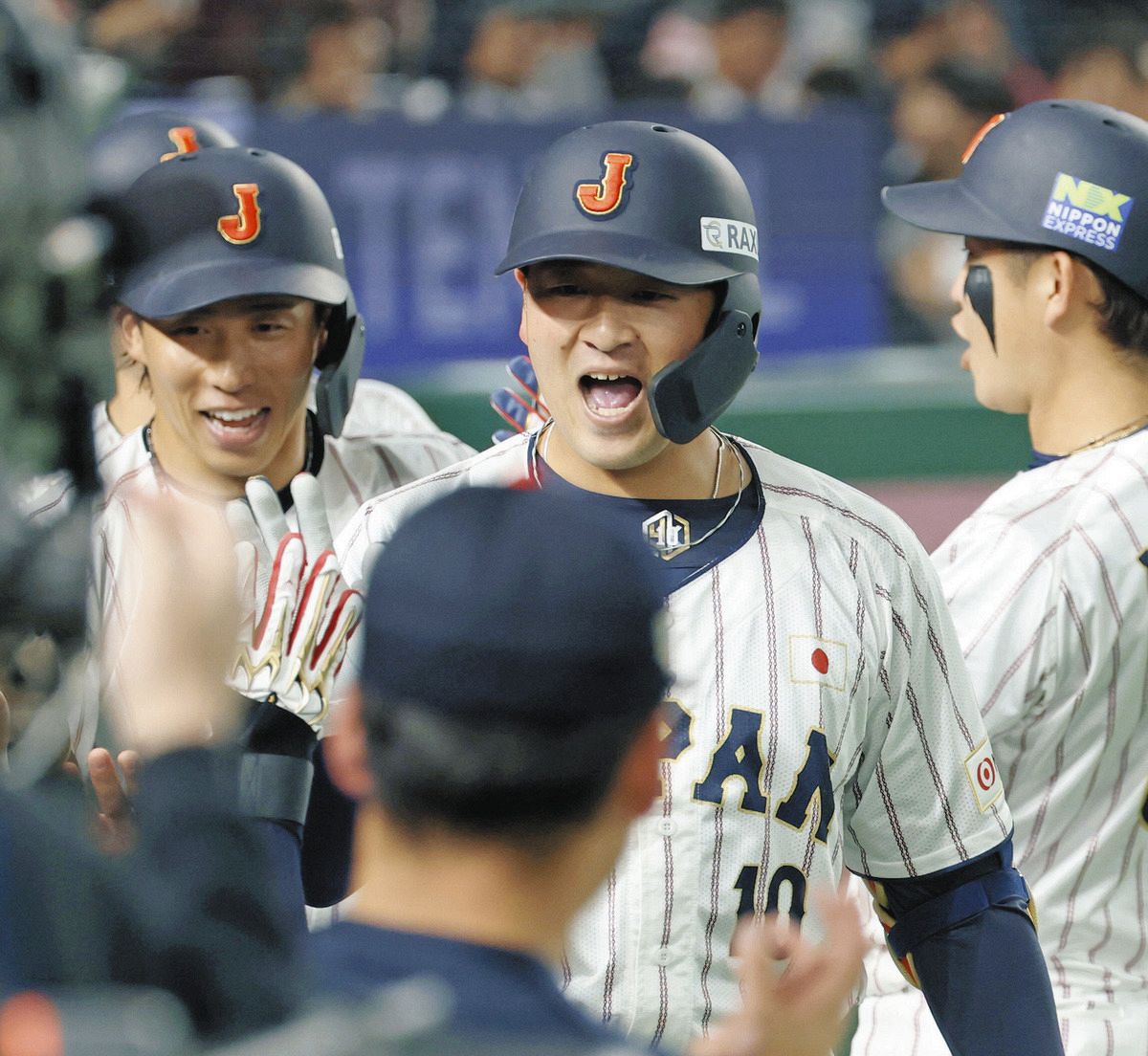 ５回裏、３ランを放ちタッチを交わす岸田