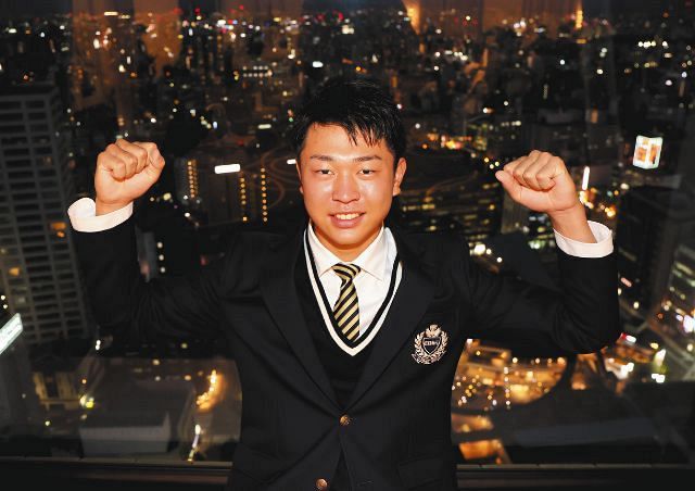 仮契約を終え、名古屋の街並みを背景に笑顔を見せる高橋宏斗