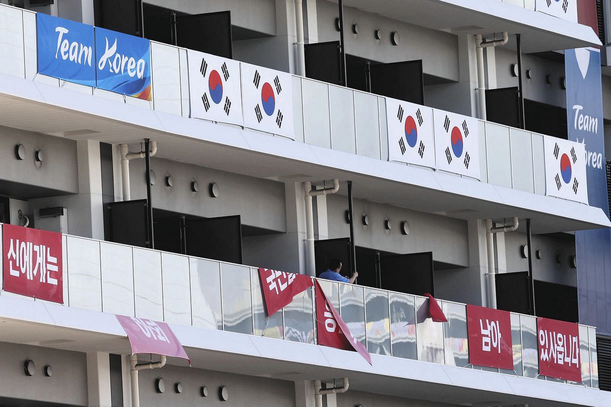 五輪選手村の居住棟に掲げた韓国の応援幕を撤去する関係者（ＡＰ）