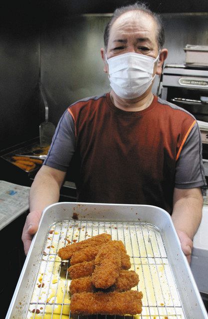 できたての「イカフライのレモン煮」を勧める新実さん＝西尾市中畑町で 