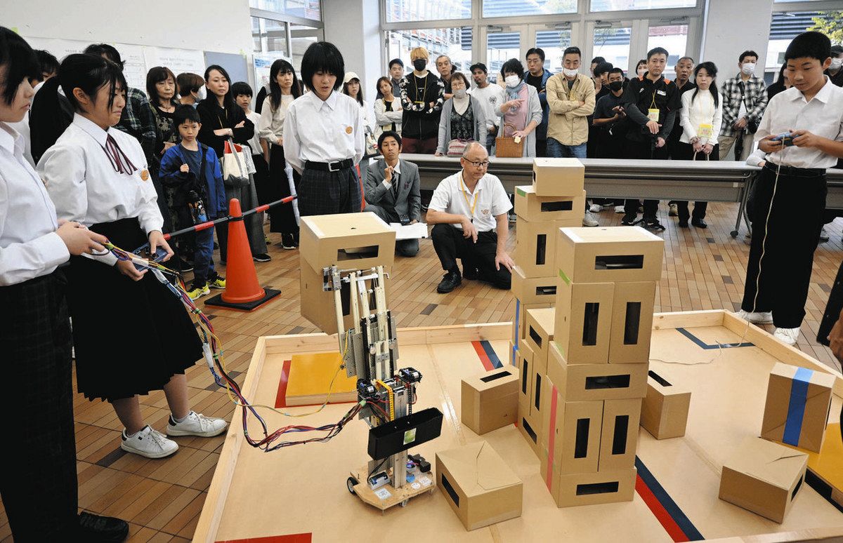 自作のロボットを使って箱を積み上げる生徒ら＝美濃加茂市蜂屋町で
