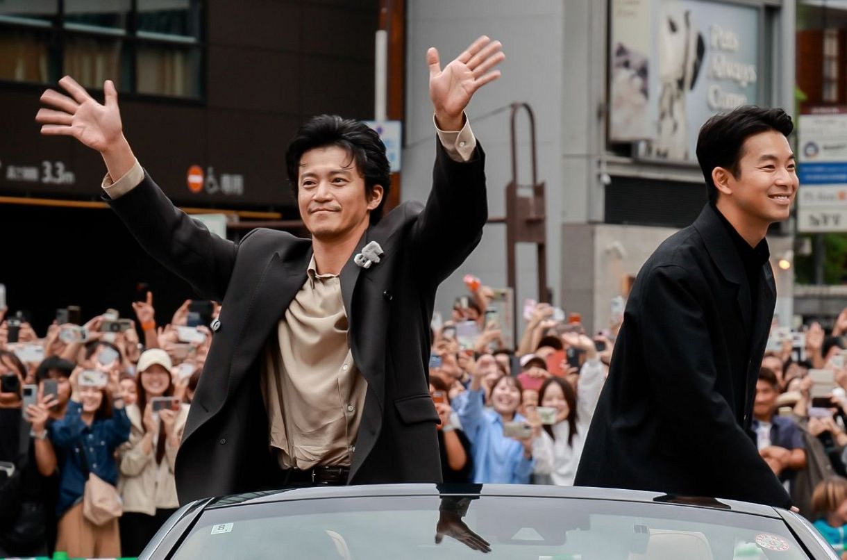 沿道の人たちの声援に応える俳優の小栗旬さん㊧と仲野太賀さん
