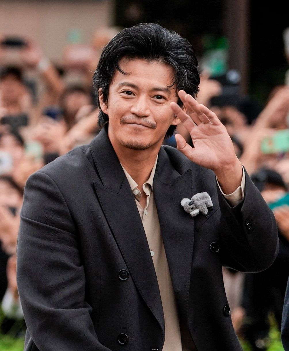 パレードで沿道の人たちに手を振る俳優の小栗旬さん