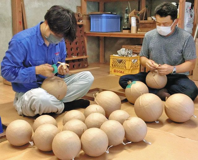 目標額達成を願って、七号玉や五号玉の最後の仕上げをする花火職人たち＝宝達志水町東間の能登煙火で 