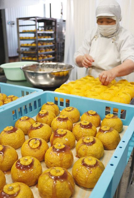 ユズに餅だねを詰める作業が進む工場=輪島市河井町で