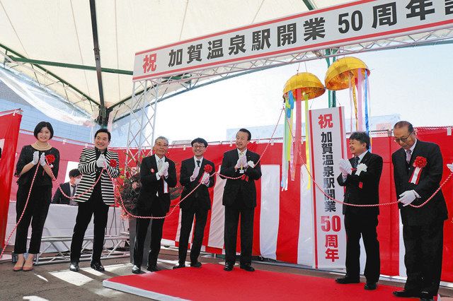 くす玉を割って加賀温泉駅開業５０周年を祝う関係者ら＝ＪＲ加賀温泉駅前広場で
