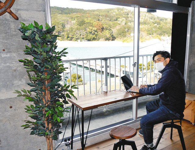 施設内の海を望み仕事ができる場所を紹介する行平さん＝鳥羽市で