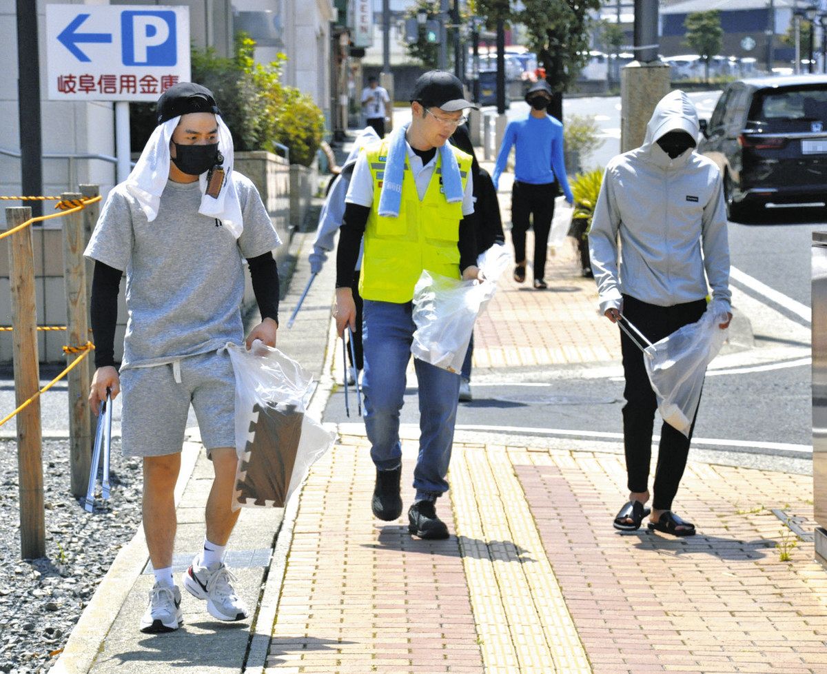 西尾さん（中）と一緒にごみを拾う技能実習生や特定技能外国人たち＝中津川市中心部で
