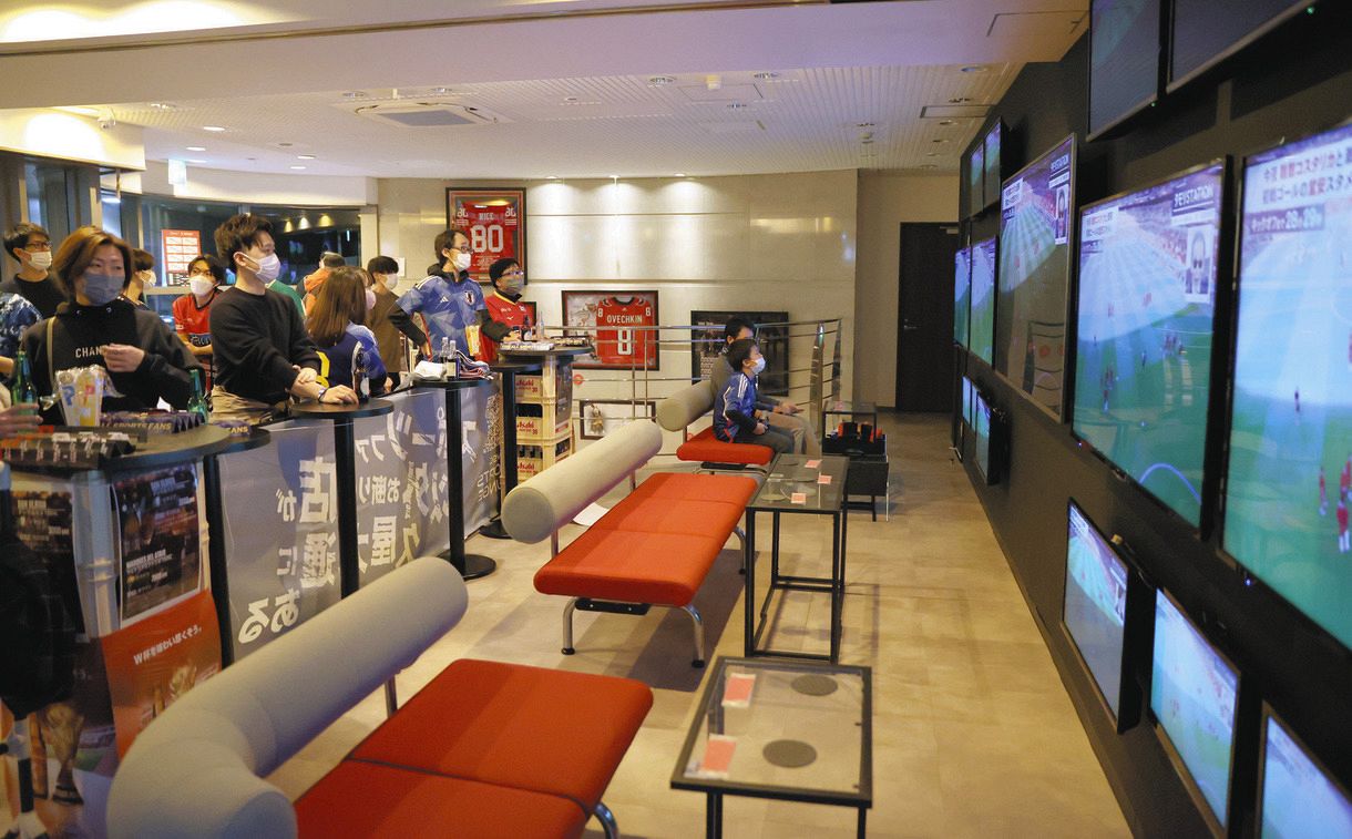 日本―コスタリカ戦のパブリックビューイングで、テレビを見ながら観戦するサポーターら＝名古屋市中区のスポーツバーで