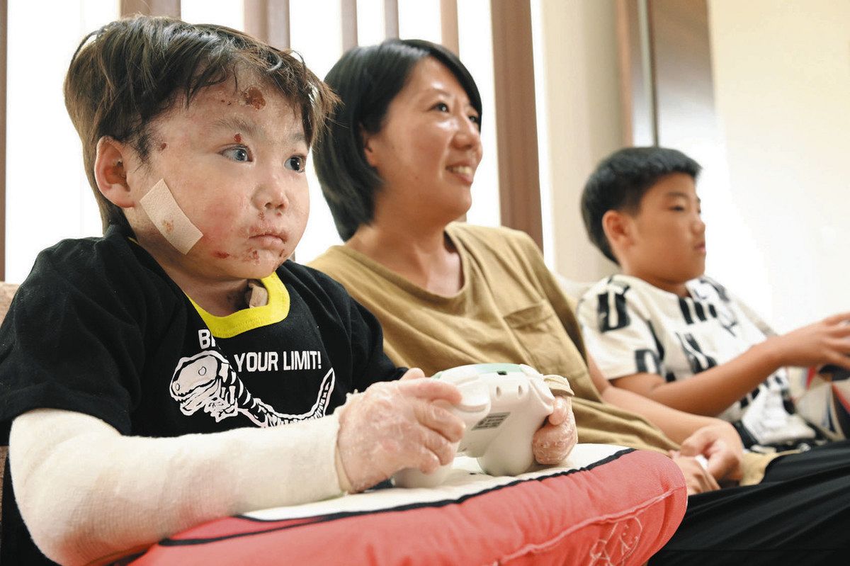 家族とテレビゲームを楽しむ田邉さん（左）＝津市で
