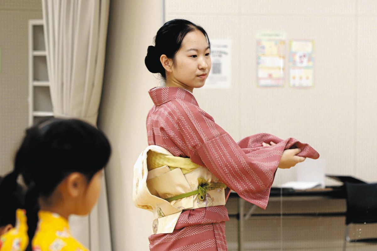 子どもたちに踊りの手本を見せる西川さん（右）＝春日井市中央台の東部市民センターで
