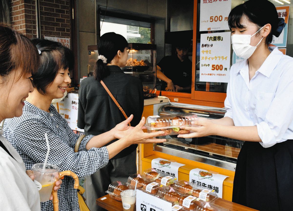 この日のために作られたハンバーガーを販売する西尾さん（右）＝中津川市新町で
