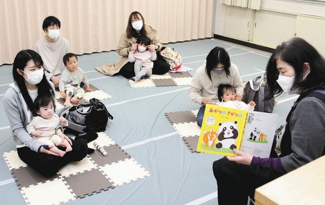 ボランティア㊨による絵本の読み聞かせを聴く親子＝名古屋市名東図書館で 