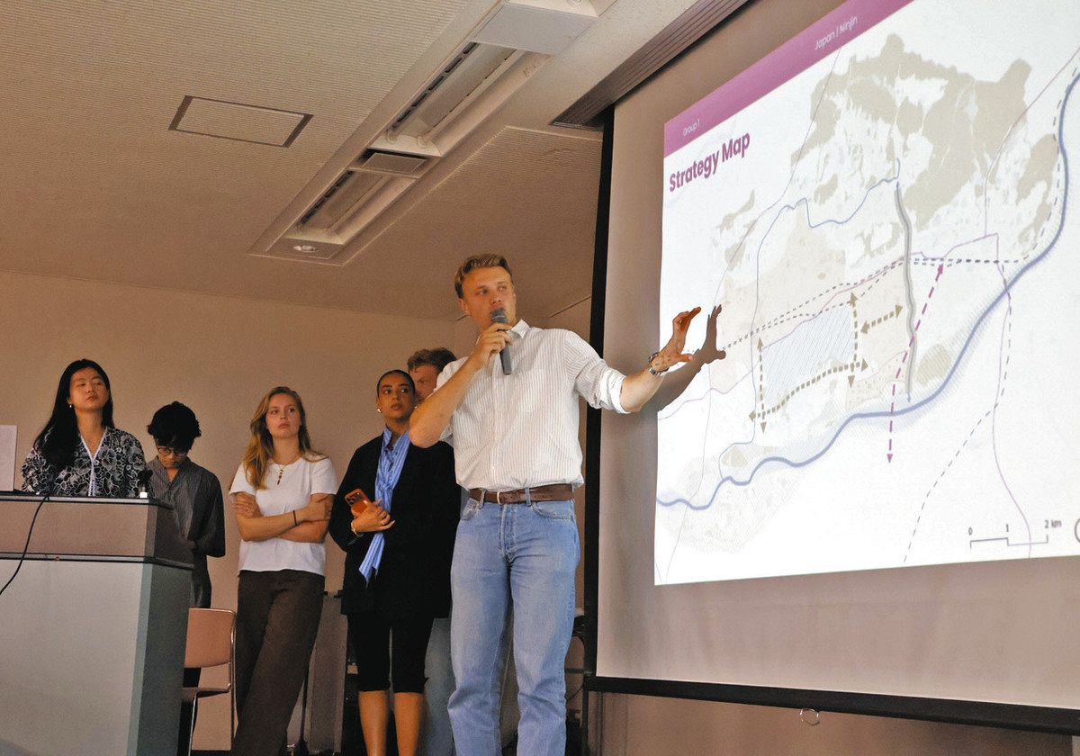 地図を示しながら地形や街の特徴を説明する学生＝各務原市産業文化センターで