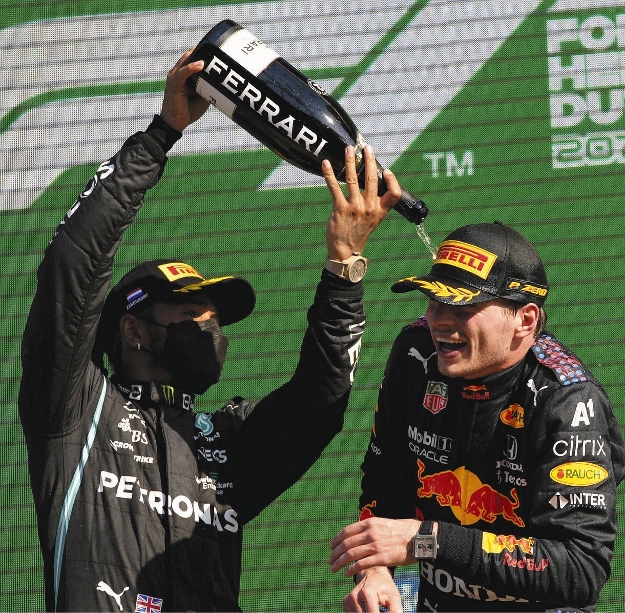 表彰台でハミルトン（左）にシャンパンをかけられるフェルスタッペン（AP）