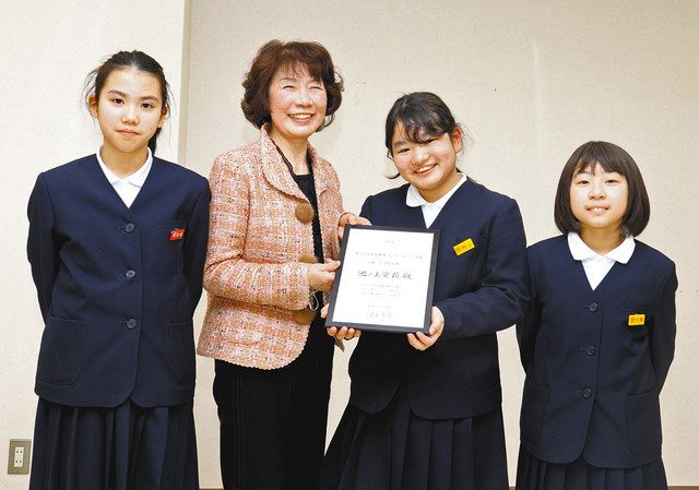 矢地幸子さん（左から２人目）から表彰状を受け取り、生け花教室の仲間から祝福を受ける池ノ上愛莉さん（同３人目）＝金沢市馬替で