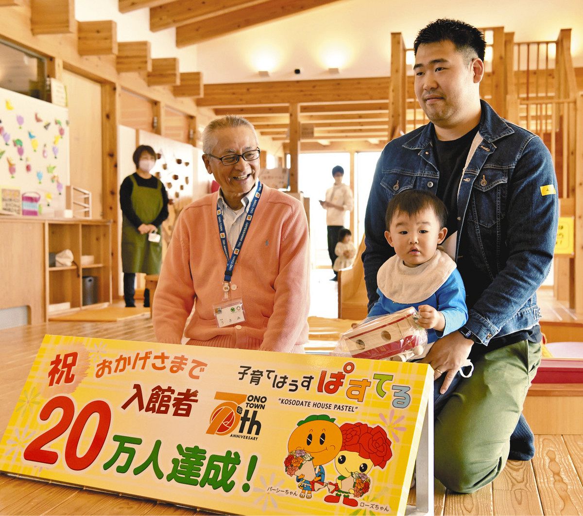 宇佐美町長（左）から記念品を受け取った谷口蒼真君（手前）と弘樹さん＝大野町下磯で