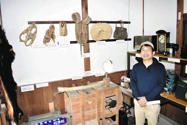 昭和３０～４０年代の民具が並ぶ展示小屋と小西さん＝おおい町名田庄染ケ谷の八ケ峰家族旅行村で 