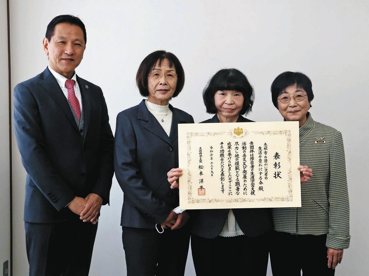 小坂市長（左）から表彰状を伝達された「恵那市の障がい児者の生活を豊かにする会」の皆さん＝恵那市役所で
