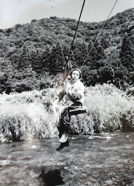 出展作のうち鷲見集落の女性をとらえた写真。手動式リフトに乗って高時川対岸の水田に向かう（１９９０年ごろ）（吉田一郎さん提供）