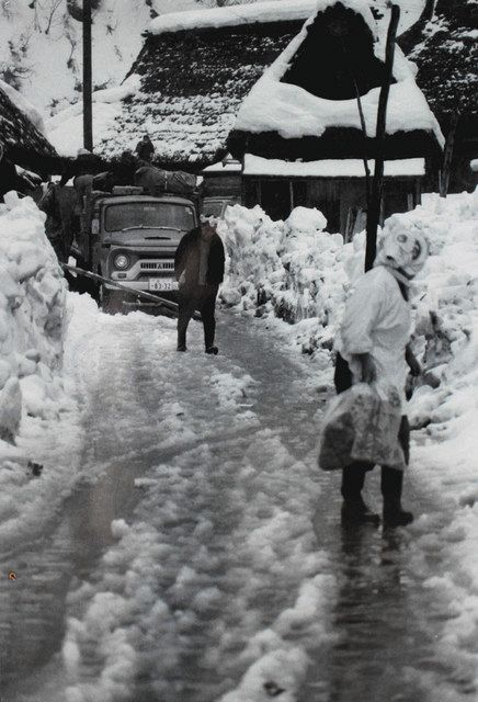写真展に出展された針川集落離村時の写真。雪が降る前に荷出しを終えるよう急かす女性（右手前）の姿が写る（１９７０年）（吉田一郎さん提供）