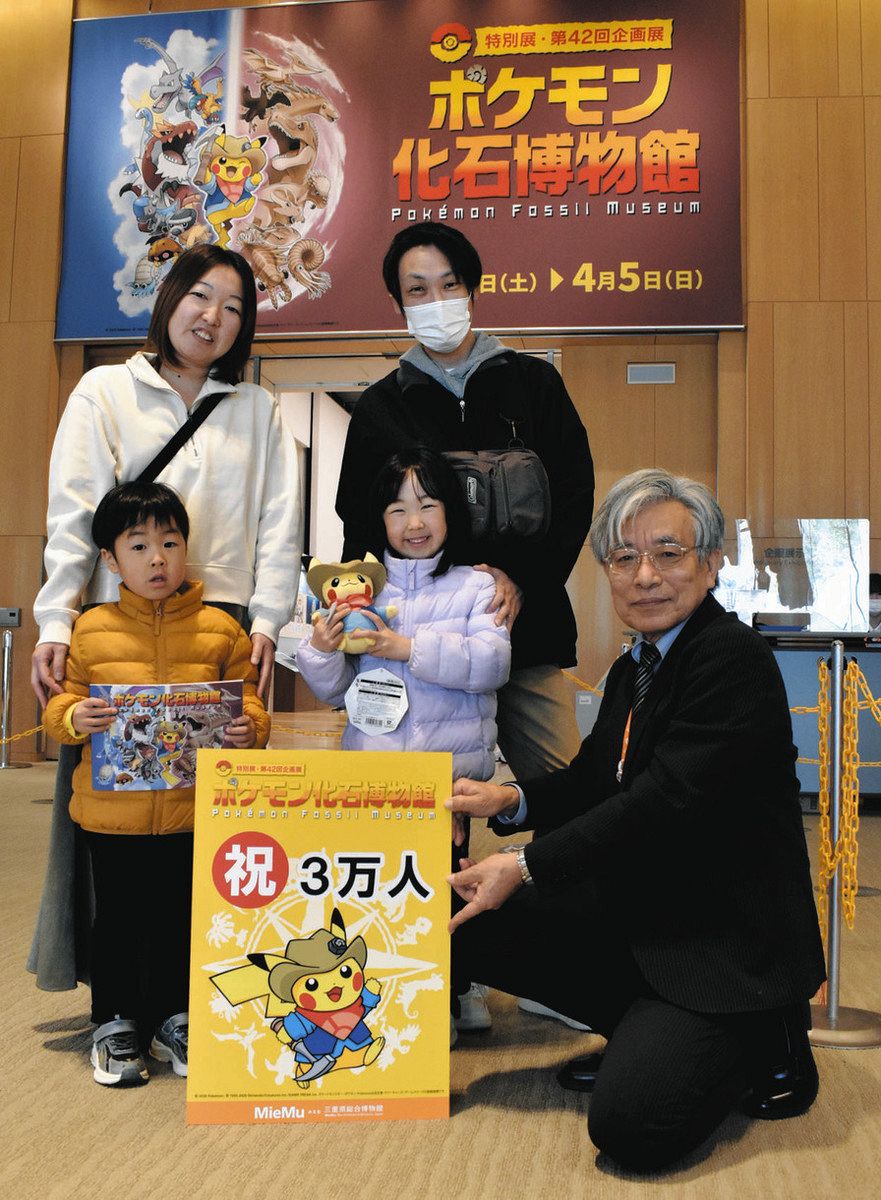 観覧者数3万人達成を祝って記念品を受け取った伊藤早咲さん（前列中央）ら＝津市の県総合博物館で
