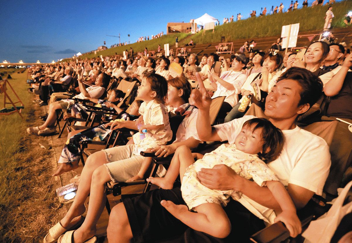 夜空を彩る大輪の花火を楽しむ来場者たち