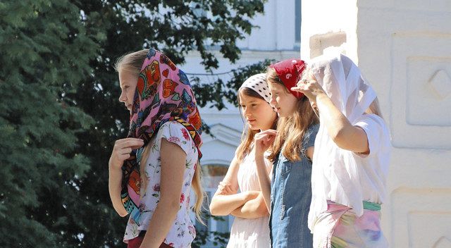 ロシアの古都スズダリで、十字を切って修道院に入る信徒たち。ロシア正教会はプーチン政権と近く軍事作戦を支持する