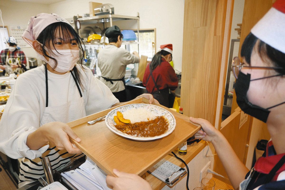 高校生（左）から完成した料理を受け取る接客担当の中学生＝福井市のなつめカフェで
