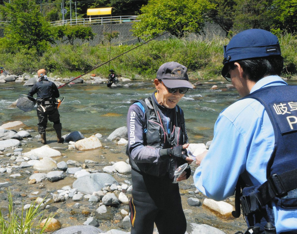 釣り客でにぎわう付知川でチラシを配る署員＝中津川市で