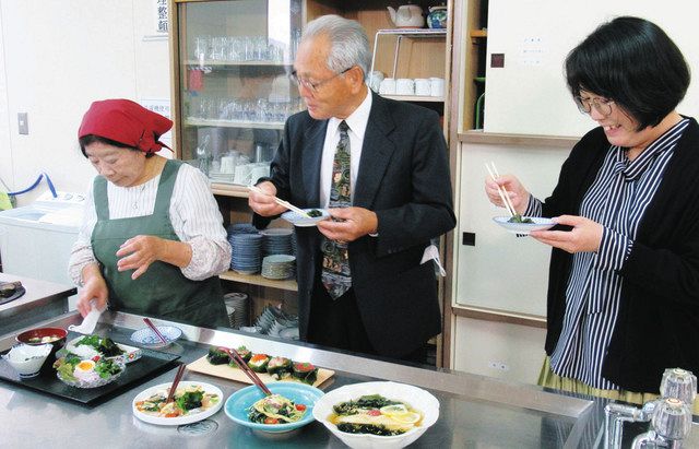 灰付けワカメを使って調理された料理を試食する、右から上沢聖子さん、水島洋組合長、竹谷てる子さん＝朝日町宮崎で