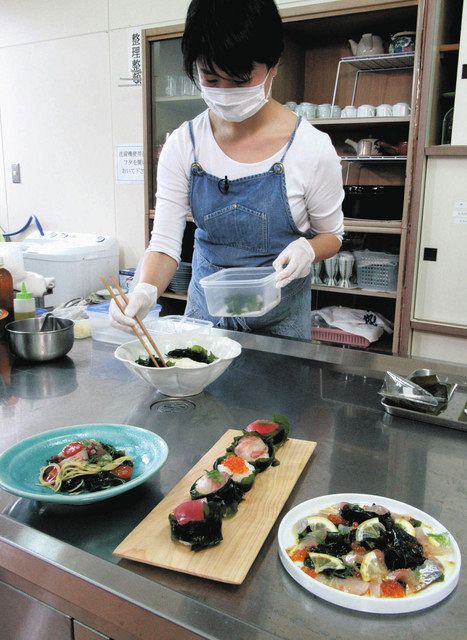 レシピブックに載せた新メニューを調理する愛場千恵子さん。手前左から灰付けワカメを使った「冷たいパスタ」「手まりずし」「カルパッチョ」＝朝日町宮崎で 