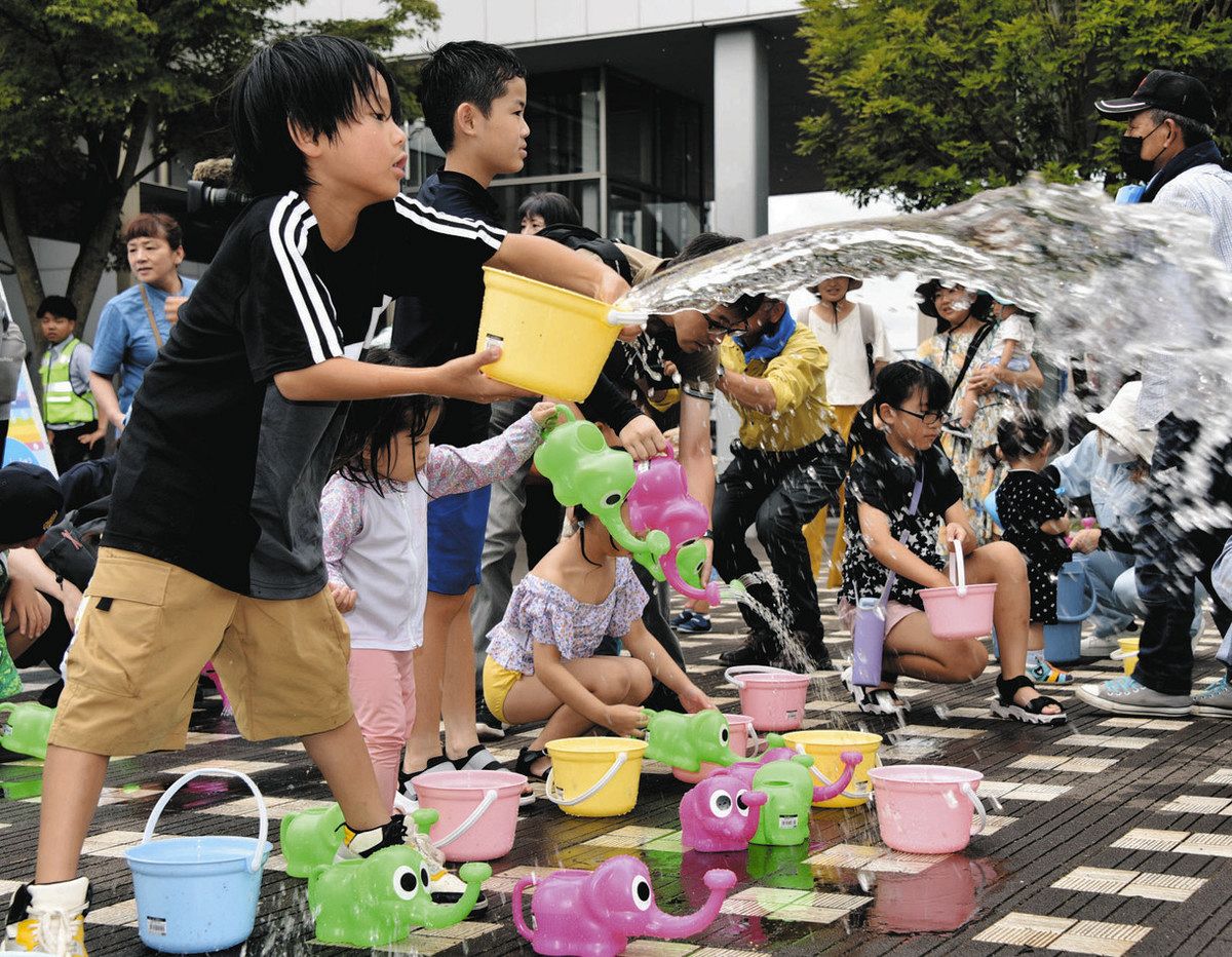 じょうろやバケツで打ち水をする子どもたち＝多治見市音羽町で
