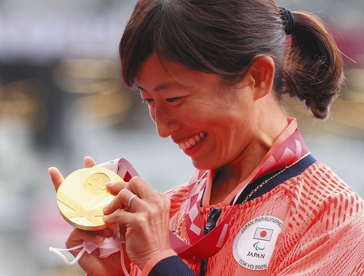 女子マラソンの表彰式で、金メダルを手に笑顔を見せる道下美里
