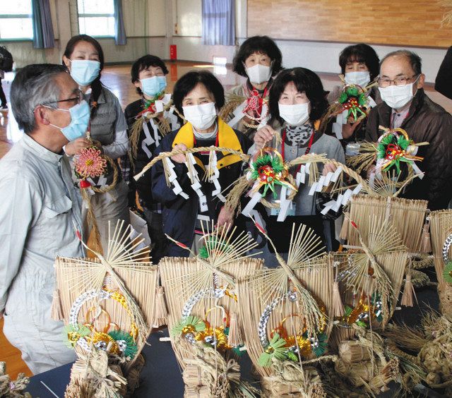 河合進さん（左）に出来上がったしめ縄飾りを見せる生徒たち＝小矢部園芸高で 
