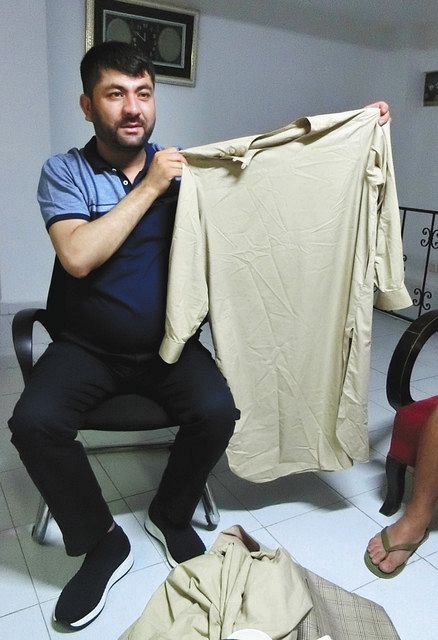 トルコのイスタンブールで２３日、脱出の際に着ていたアフガンの伝統衣装を見せるムラディンさん＝蜘手美鶴撮影 