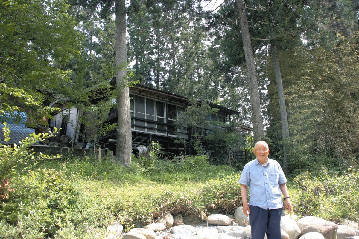２０年かけて作った別荘の前に立つ辻本正二さん
