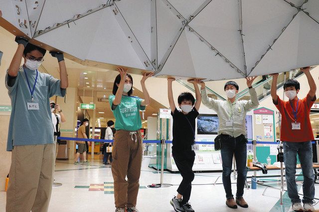 力を合わせて段ボール製テントを組み立てる参加者ら＝加賀市作見町で