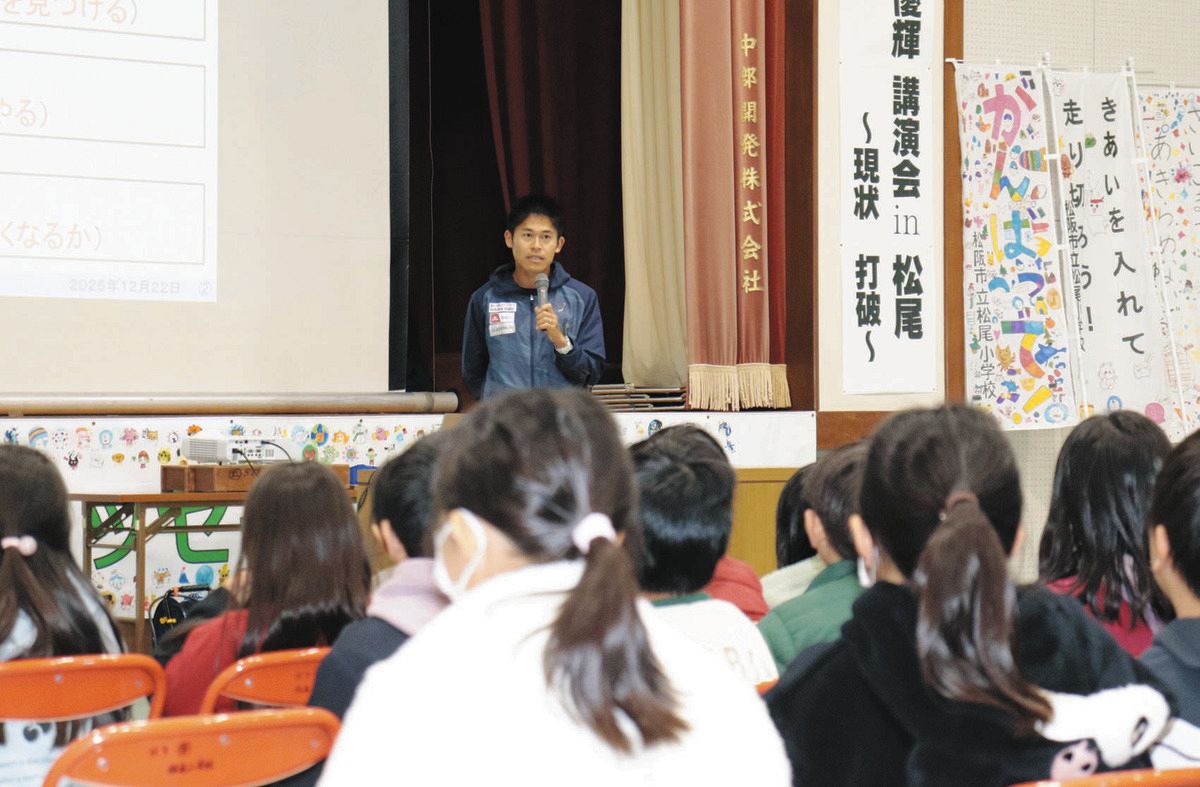 子どもたちの前で講演する川内選手＝松阪市松尾小で