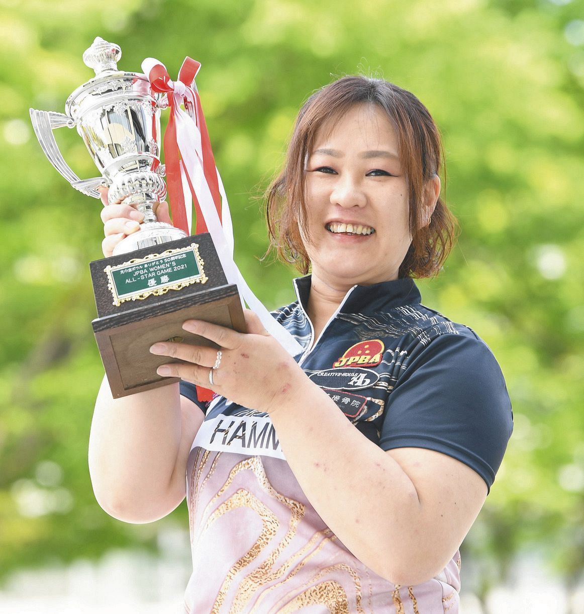 優勝カップを掲げる女子プロボウラーの丹羽由香梨