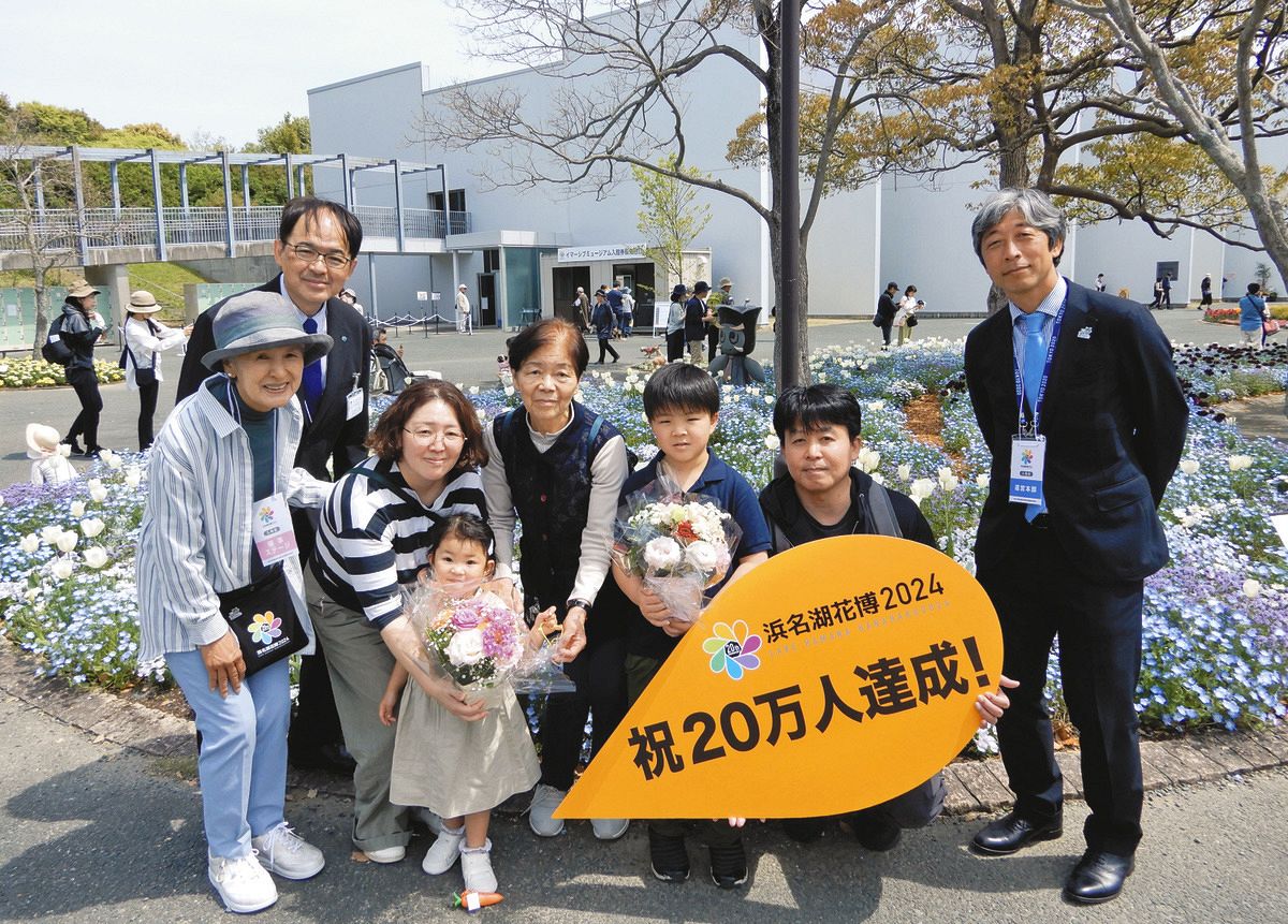 浜名湖花博２０２４の２０万人目来場者となった二本柳亘児さん（右から２人目）一家と花博実行委員の塚本こなみさん（左）ら＝１５日午前、浜松市中央区村櫛町の浜名湖ガーデンパークで