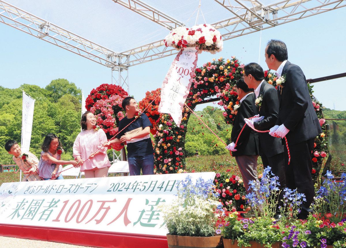 くす玉を開き祝う糟谷さん一家ら＝可児市瀬田のぎふワールド・ローズガーデンで