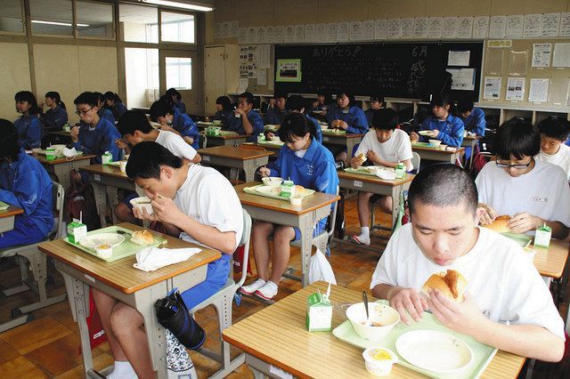 授業を受けるのと同じ席の配置で給食を食べる生徒たち＝湖西市の鷲津中で