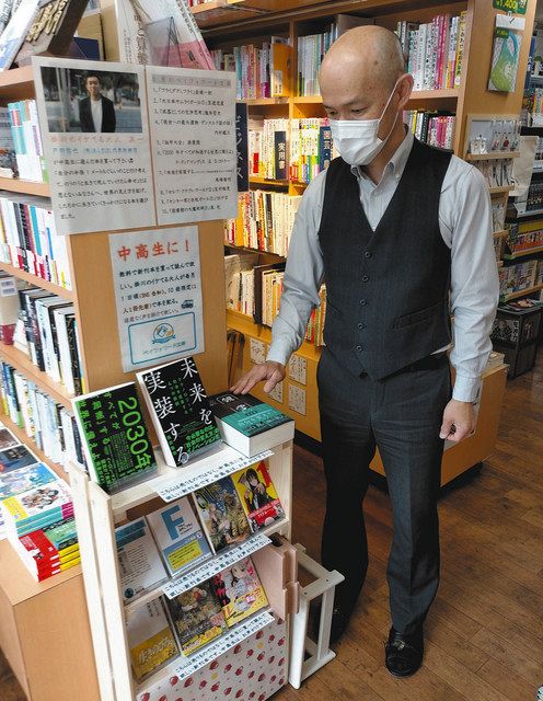 ６月から始まる「ペイフォワード文庫」を紹介する高木久直さん。初回は戸田佑也さんの選書１０冊が並ぶ＝掛川市掛川の高久書店で
