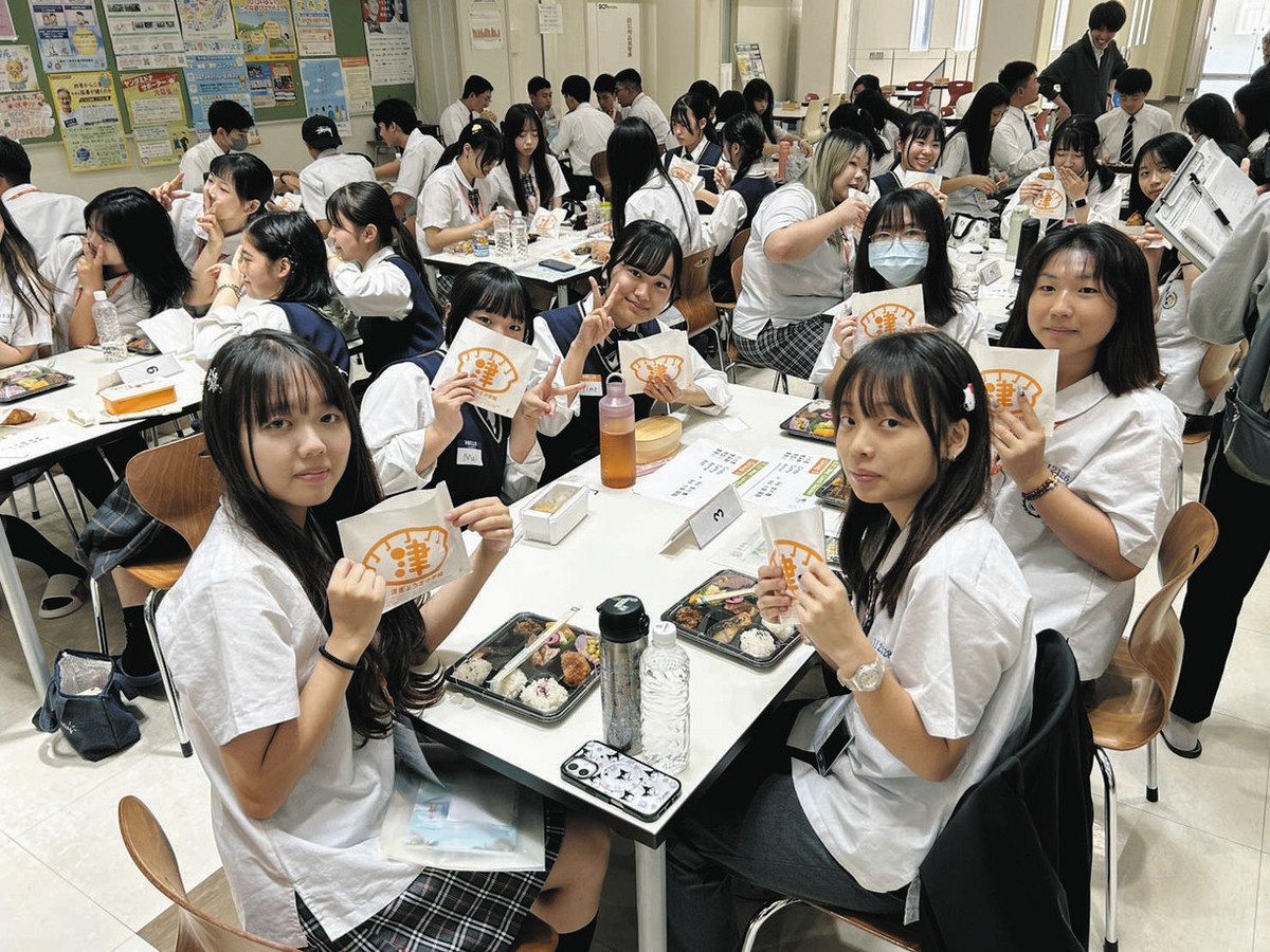津ぎょうざを一緒に食べた台湾と高田高校の生徒ら＝津市一身田町の高田高で（津ぎょうざ小学校提供）
