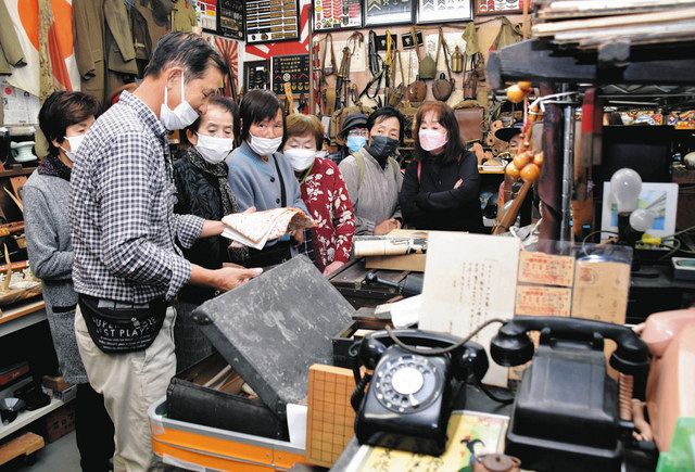 戦時中の千人針を見せる柳川さん（左）＝川辺町中川辺の珪化木の不思議館で