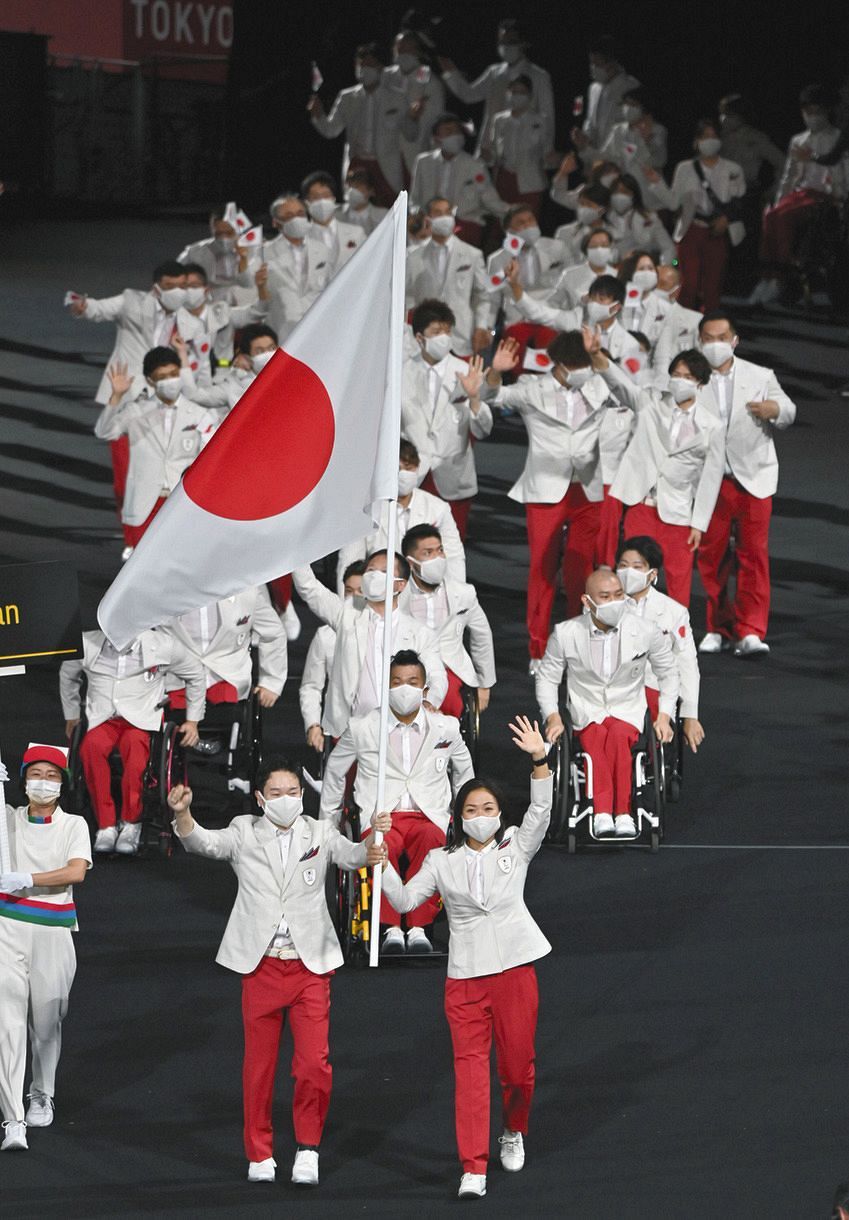 開会式で、旗手を務める岩渕幸洋（手前左）、谷真海（同右）を先頭に入場行進する日本選手団