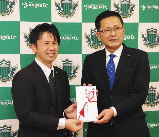 萩原社長から寄付金を受け取った青木理事長（左）＝松本市並柳の松本山雅事務所で 