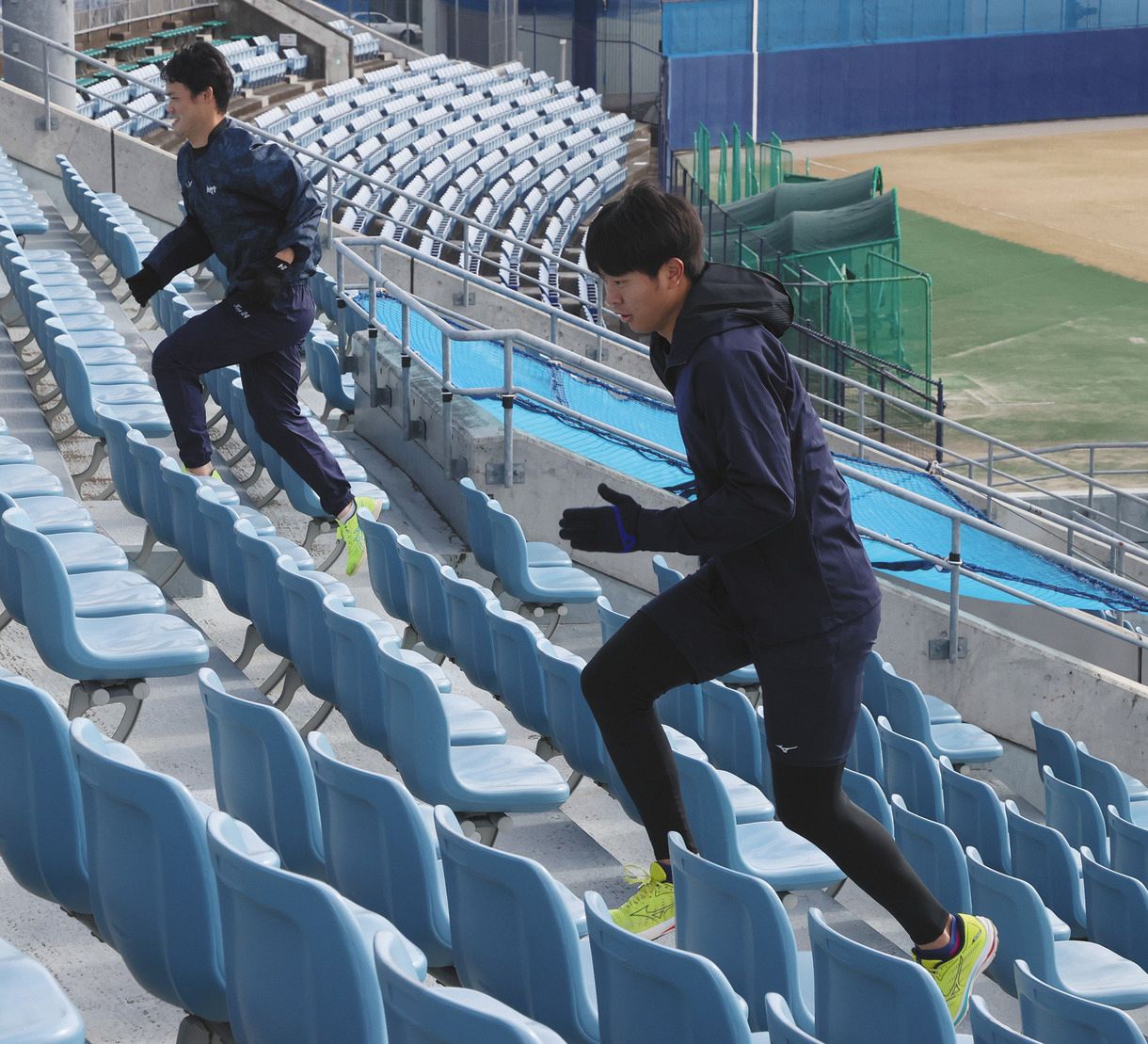 スタンドの階段でトレーニングする高橋宏（手前）と福谷
